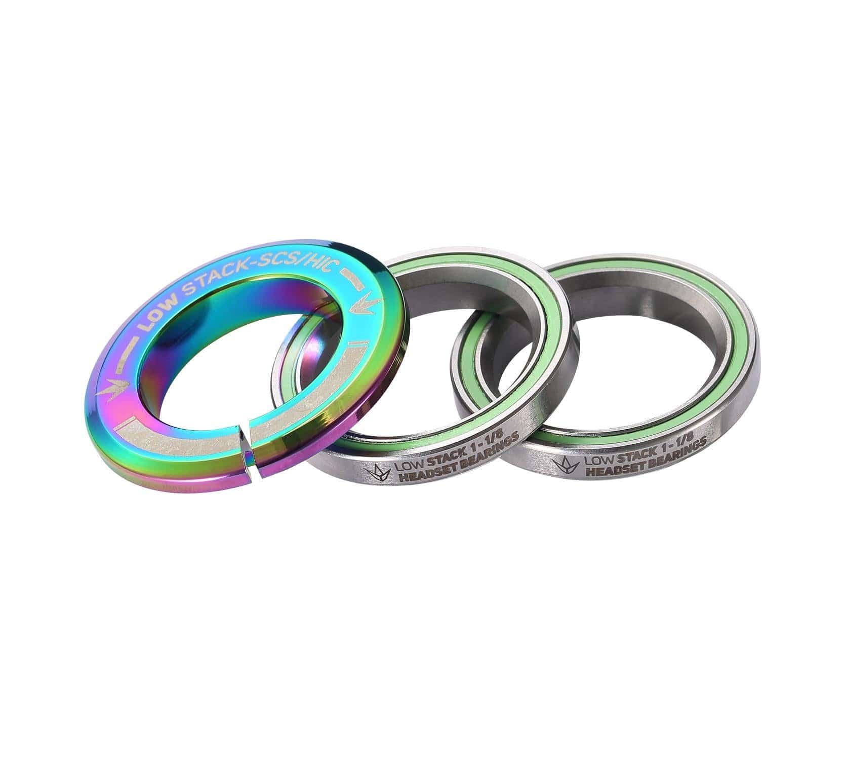 The Blunt Envy Low Stack SCS Integrated Stunt Scooter Headset features three metallic spacers with a stunning oil slick neochrome finish. The largest spacer is labeled for compatibility with the SCS compression system, while the others display measurement inscriptions. These circular spacers have a smooth outer texture.