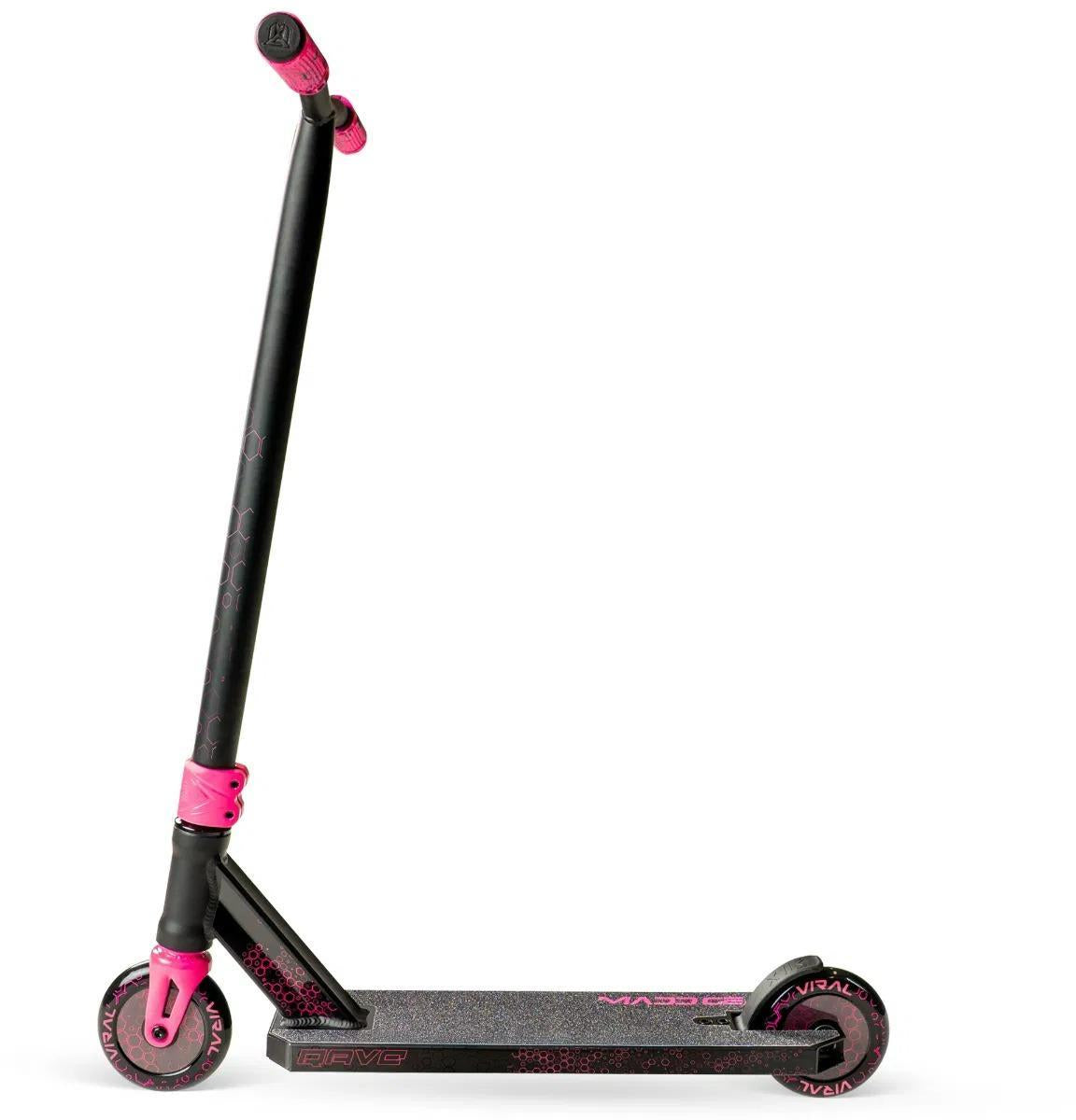 The Madd Gear Viral Rave Complete Stunt Scooter - Melon features vibrant pink wheels, grips, and clamp on a black deck with textured surface and subtle pink designs. This MGP scooter stands upright, ready for your next trick.