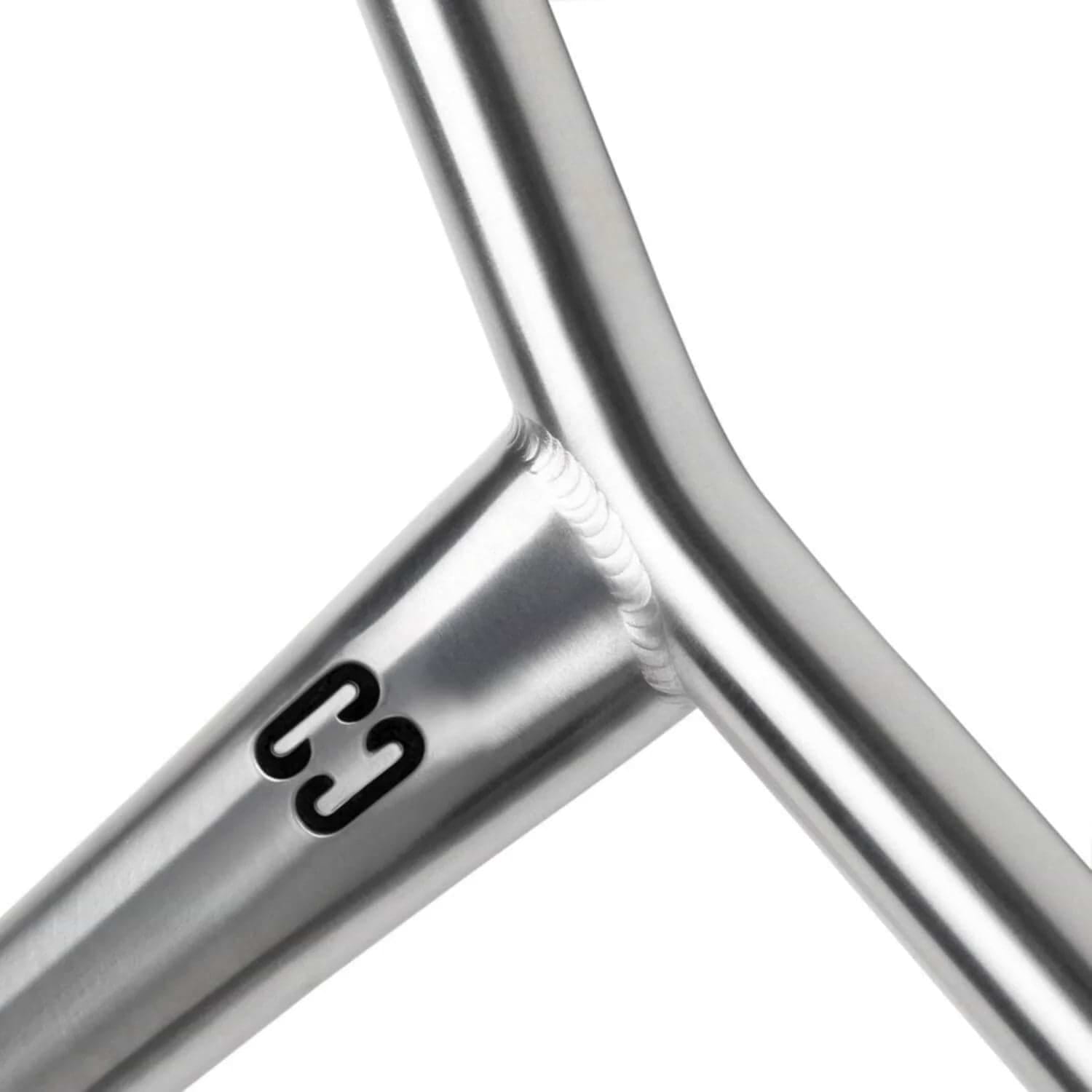 Close-up of a metallic frame joint, forming a Y-shape with smooth silver surfaces and a welded connection. Featuring the black "C3" logo on the tube, this component is crafted from space-grade titanium used in CORE Apollo V2 Titanium Oversized HIC Stunt Scooter Bars, ensuring strength and a polished finish.