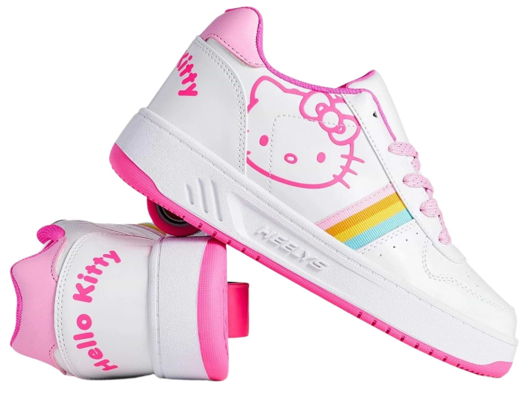 The Heelys x Hello Kitty Kama Girls Shoes in white and pink feature playful Sanrio Hello Kitty designs, rainbow side stripes, and "Hello Kitty" text on the heel; one shoe stands upright while the other shows the wheel.