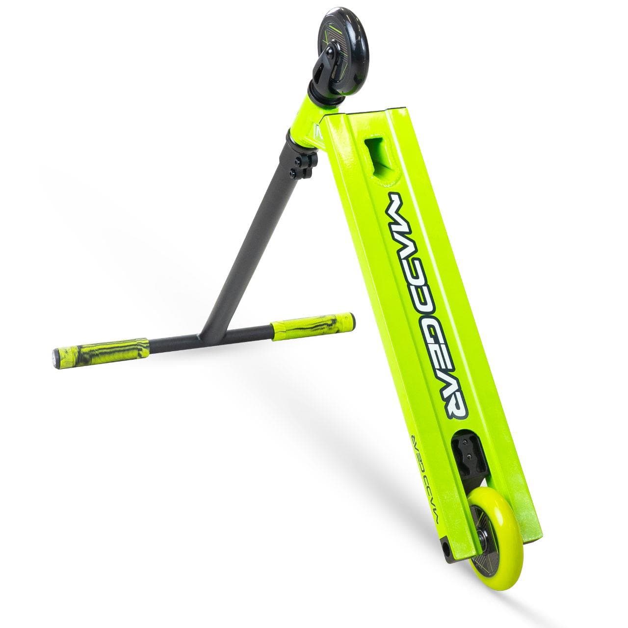 The Madd Gear MG 1 Raven Complete Stunt Scooter in Lime/Black features two wheels, black handlebars, and a sleek rectangular deck with "MAD GEAR" branding. This MGP kids scooter is shown angled on its side.