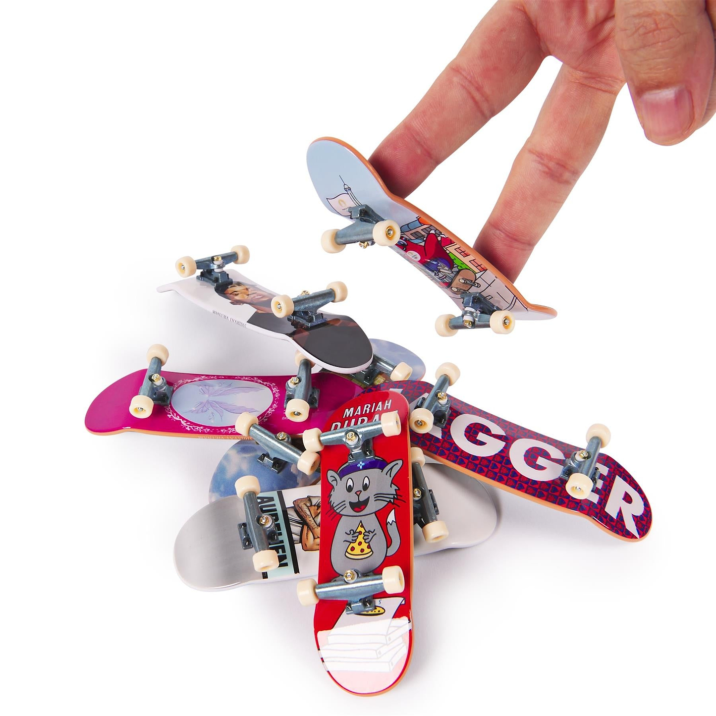 A hand rides a miniature skateboard above a stack of colorful Tech Deck Olympic Competition Legends Fingerboards—8 Pack, perfect for aspiring competition legends and fans of the Paris 2024 Olympic Games.
