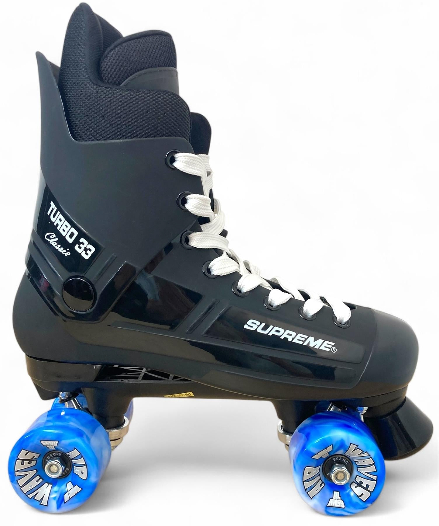 The Supreme Turbo 33 Nylon Quad Roller Skates feature a black boot, thick ankle padding, white laces, and four blue swirl wheels. Shown against a plain white background.