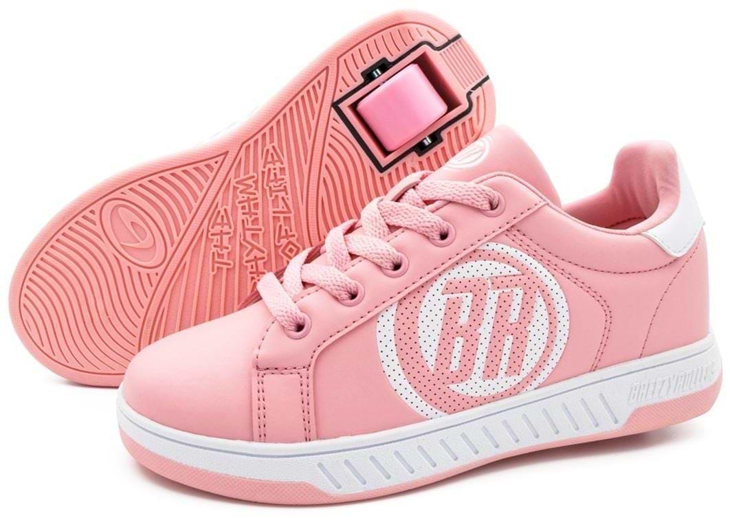 A pair of Breezy Rollers Classic Shoes - Pink / White features patented heel wheels and a circular side logo. One Breezy Rollers sneaker stands upright while the other lies on its side, displaying the wheel system.
