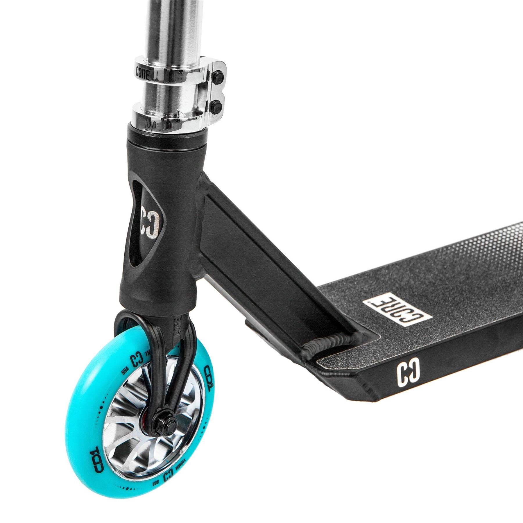 Close-up of the CORE CD1 Complete Stunt Scooter in Chrome/Teal, showing a teal wheel with metallic spokes, textured deck, and visible CORE logo on the frame and foot deck.