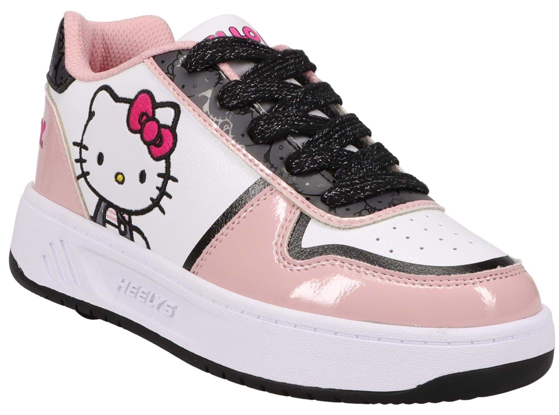 The Heelys x Hello Kitty Kama HKC Girls Shoes in light pink, black, and white feature a Hello Kitty graphic and "Heelys" embossed on the sole—perfect for fans of both brands.