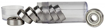 A clear tube containing Sushi Chrome ABEC 5 Skateboard Bearings by Sushi rests on its side, with several shiny cylindrical bearings neatly arranged around it. A detached cap lies to the left, highlighting the quality of this 8-pack set.