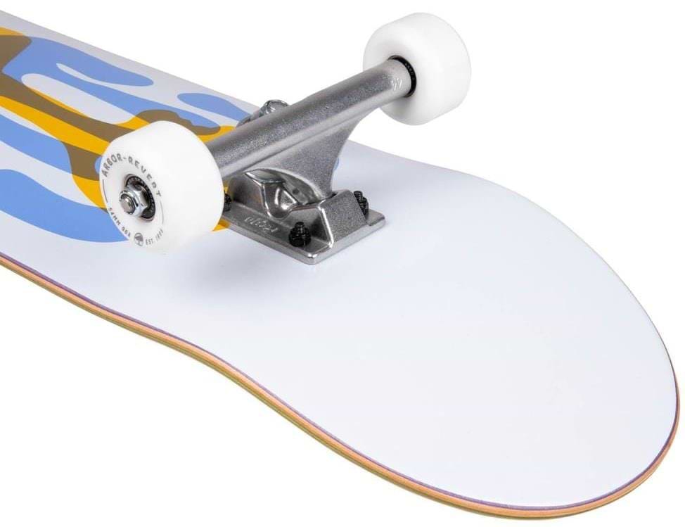 Close-up of the Arbor Street Logo Blue Complete Skateboard (7.75" x 31.5") by Arbor, featuring white wheels, silver truck, and a blue, yellow, and white deck with visible layered Canadian maple construction at the board’s edge.