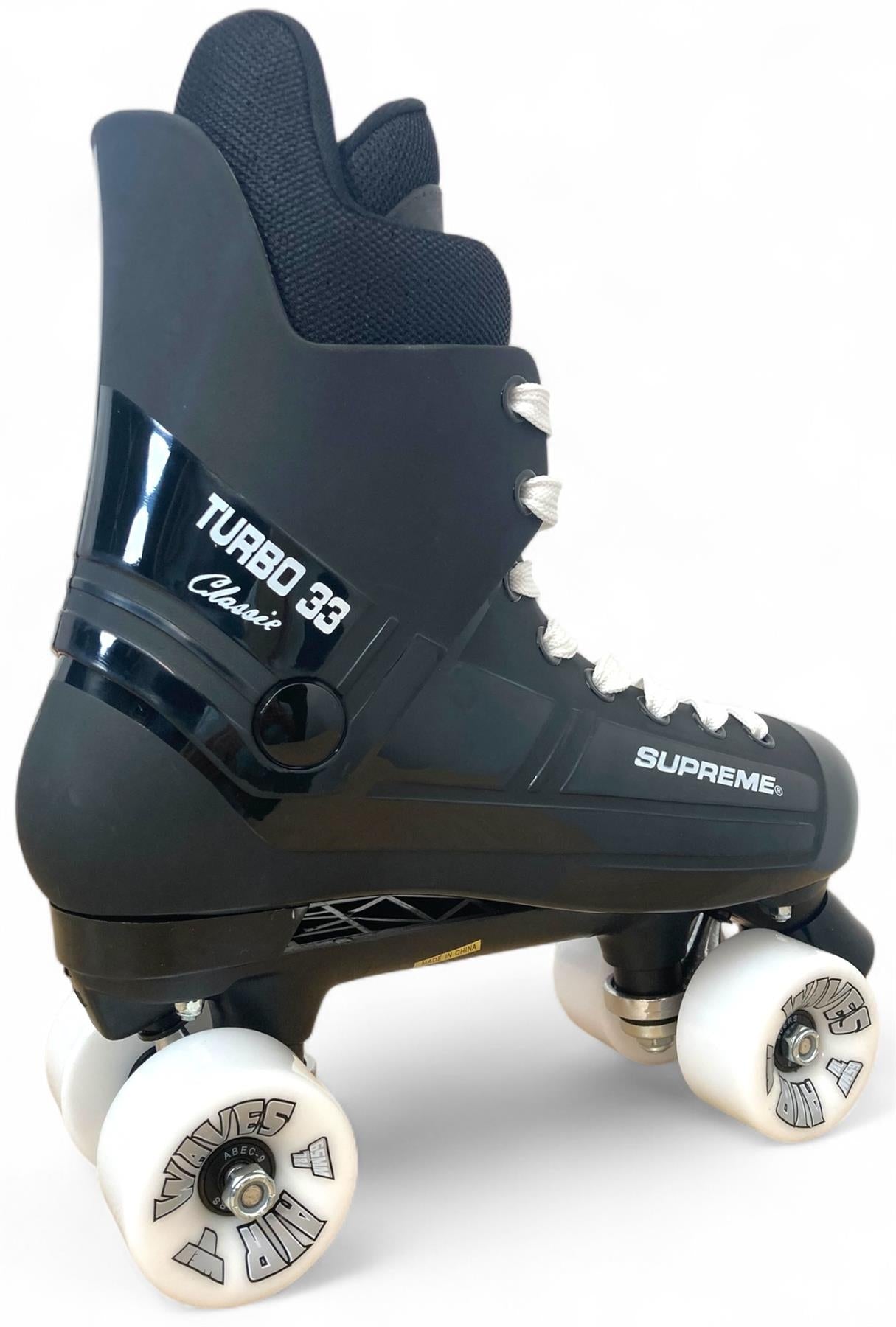 The Supreme Turbo 33 Nylon Quad Roller Skates in black feature white wheels, white laces, "TURBO 33 Classic" and "SUPREME" on the side, padded ankle support, and KRYPTOS-branded wheels.