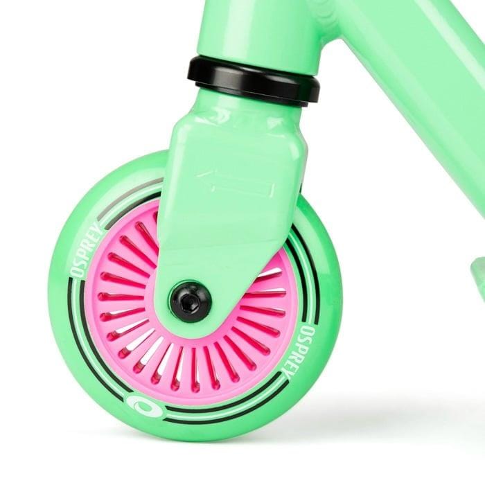 Close-up of the Osprey Bomb Complete Stunt Scooter - Pink / Green, featuring a green wheel with pink spokes and "Osprey" branding on the rim—perfect for entry-level riders.