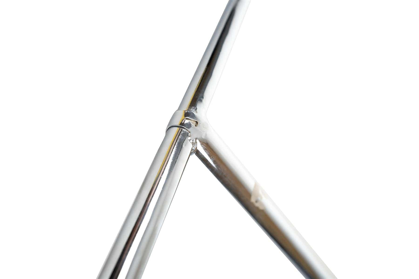 Close-up of the corner of a Supremacy Trojan Steel Oversized SCS Stunt Scooter T-Bar in chrome finish, featuring a polished, gleaming joint where two silver rods intersect against a white background.