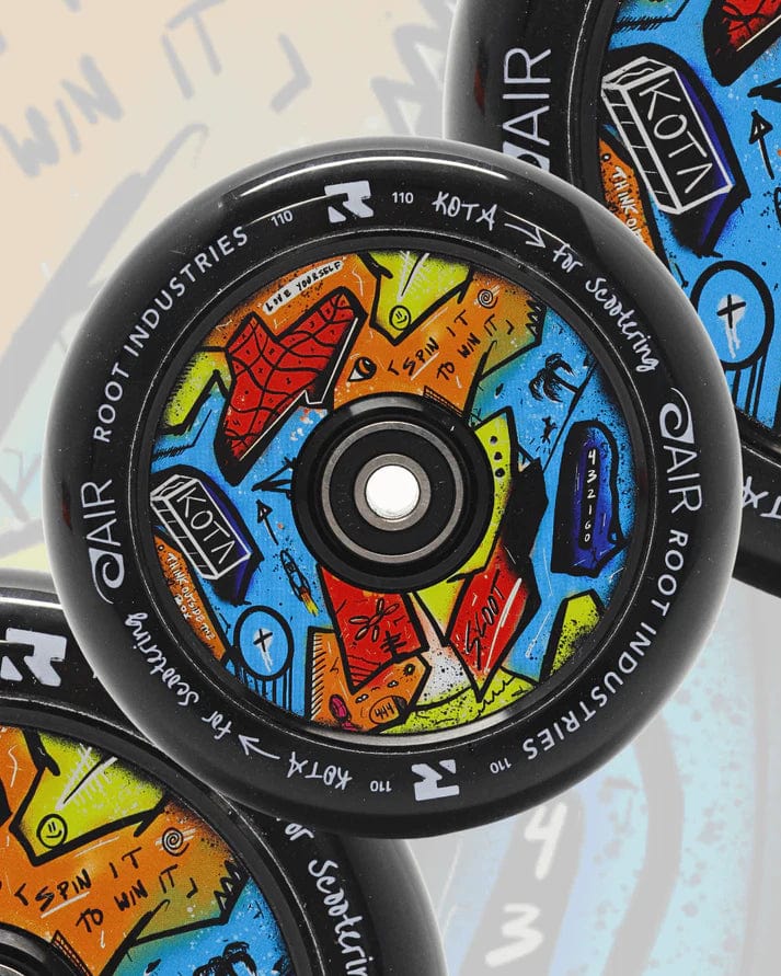 Close-up of the Root Industries x KOTA Limited Edition AIR 110mm Stunt Scooter Wheel in black, featuring bold, graffiti-style artwork in blue, orange, yellow, and red—a top pick for stunt scooter enthusiasts.