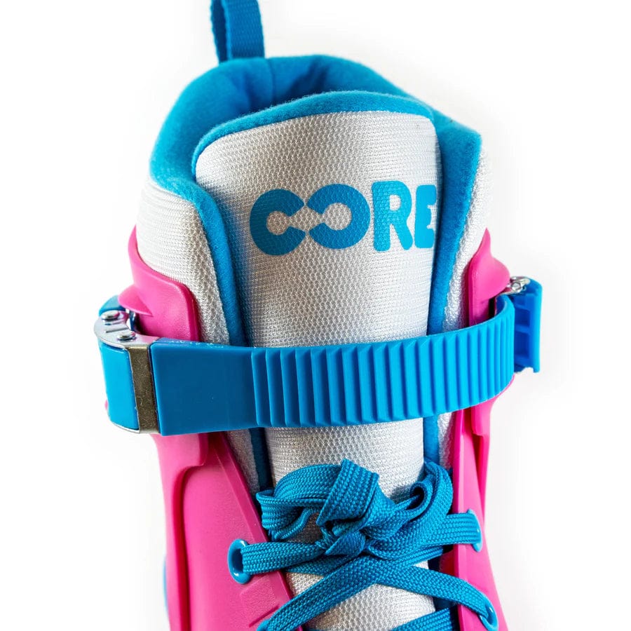 Close-up of a vibrant "CORE Retro Adjustable Inline Skates" in pink and blue, crafted for top-tier performance. The skates include a blue strap, while "CORE" is boldly printed on the tongue in blue. A bright blue interior lining provides comfort with every glide.