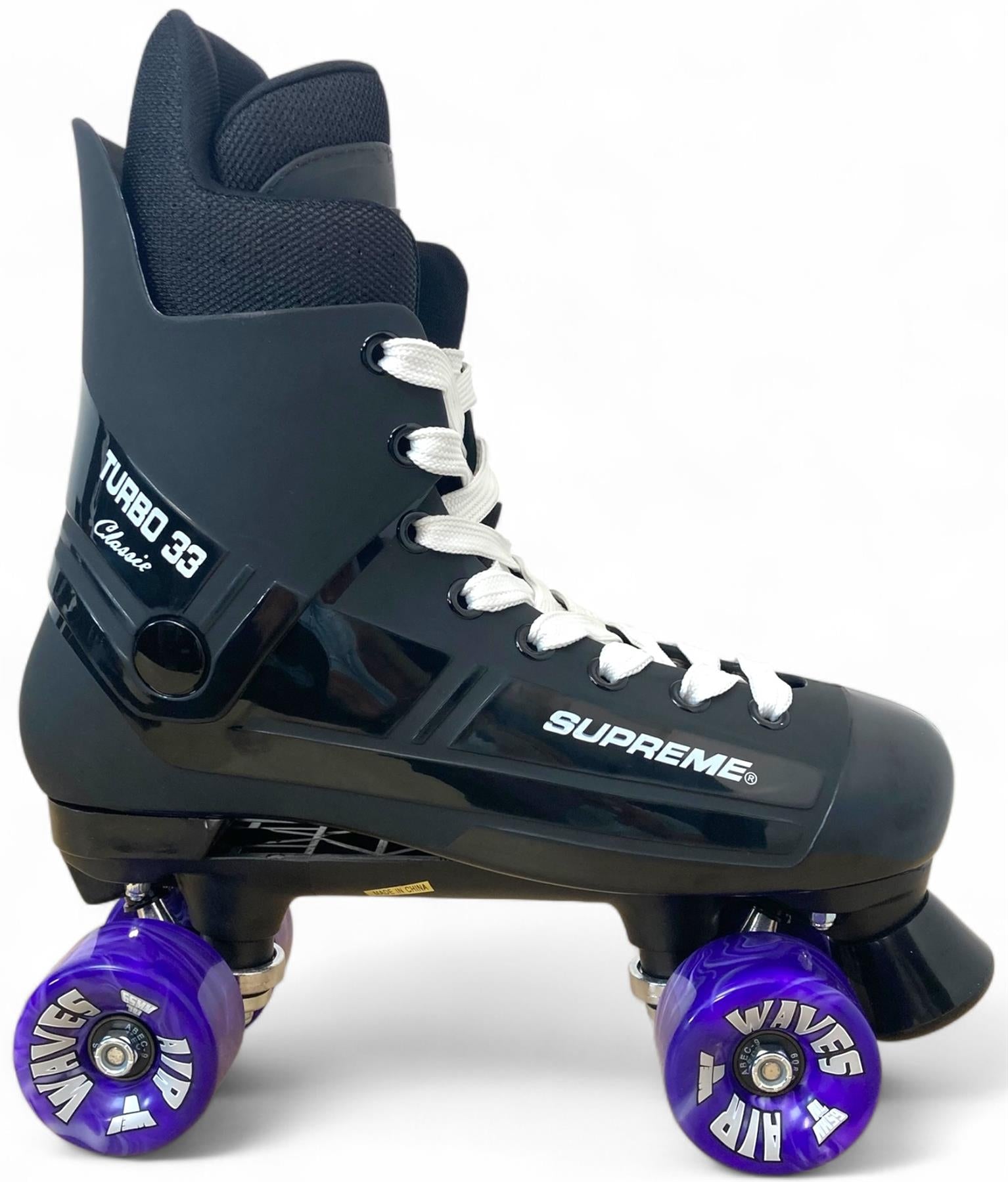 The Supreme Turbo 33 Nylon Quad Roller Skates in black feature white laces and purple swirl wheels, shown in profile against a plain white background.
