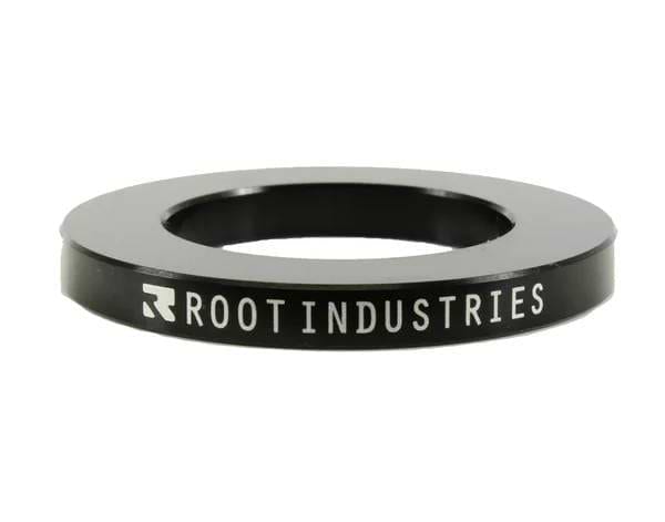 The Root Industries 5mm Headset Spacer - Black is a circular spacer with "ROOT INDUSTRIES" in white on the side, featuring a wide central hole—perfect for SCS compression setups.