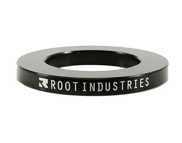 The Root Industries 5mm Headset Spacer - Black is a circular spacer with "ROOT INDUSTRIES" in white on the side, featuring a wide central hole—perfect for SCS compression setups.
