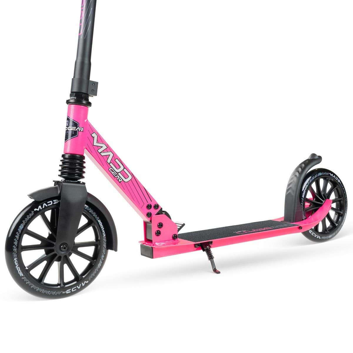 The Madd Gear Metro Cruise 250 Foldable Commuter Scooter in Black/Pink features large black wheels, a black grip footboard, adjustable height handlebars, and a side kickstand. Shown on a white background. Brand: Madd Gear (MGP).