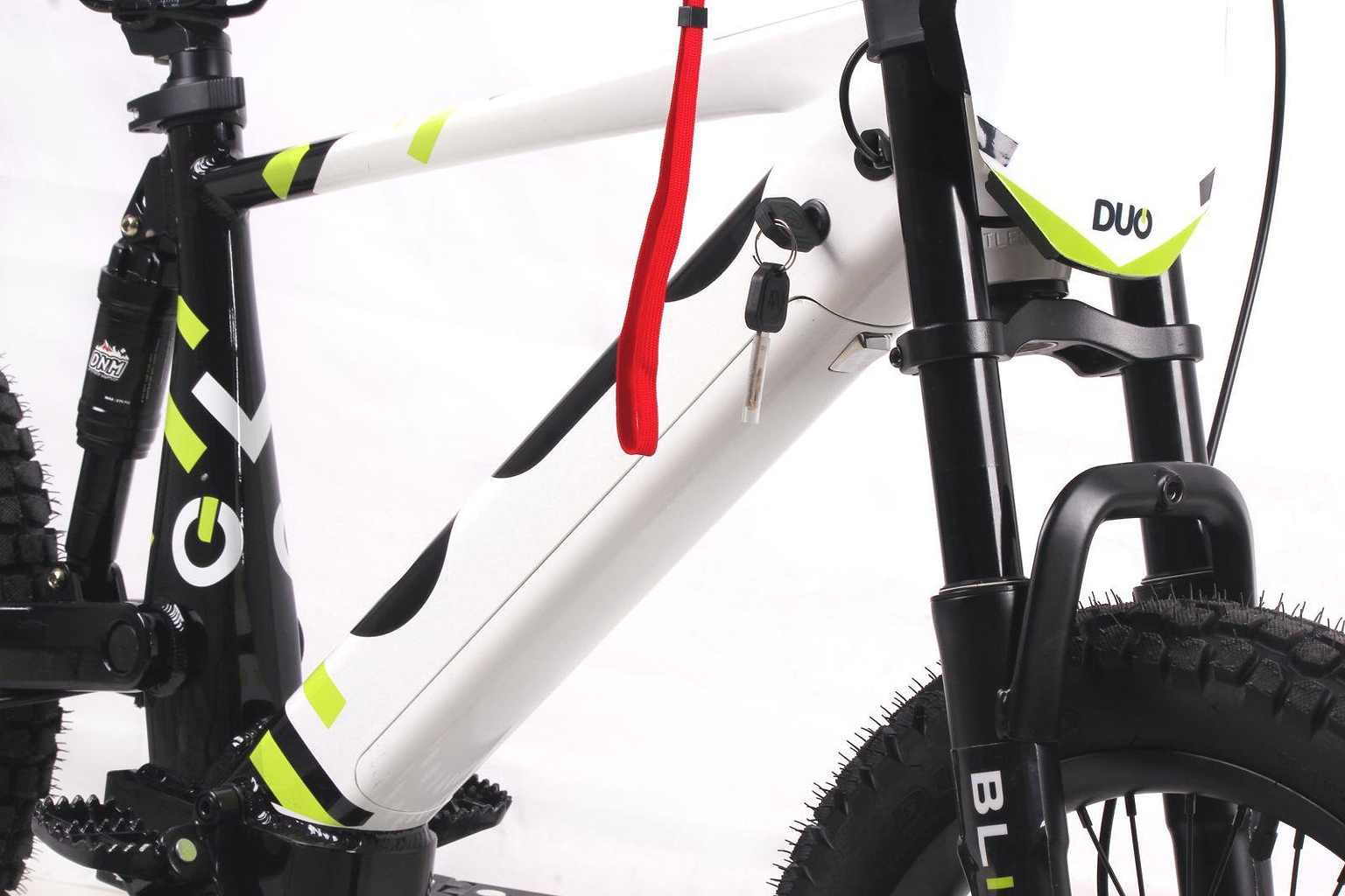 Close-up of the Duo 20" Blitz Kids Electric Balance Bike in white and black, featuring front suspension, key in battery compartment, red strap, thick knobby tires, and "DUO" branding on the front panel.