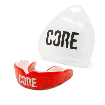The CORE Skate Protection Mouthguard in red, crafted for maximum protection, prominently features the "CORE" branding. It is presented with a clear storage case that also showcases the "CORE" logo, emphasizing its impact-absorbing properties.