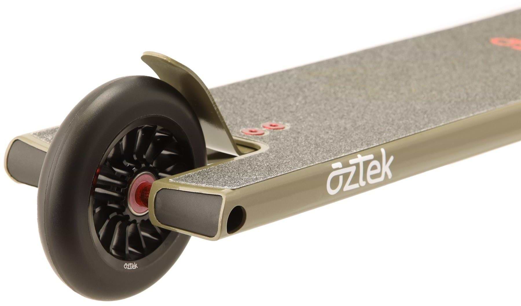 Close-up of the rear end of an Aztek Architect 2 Complete Stunt Scooter in Zircon Sand, featuring a matte gold deck, black rear wheel, grip tape surface, and a white "Aztek" logo on the side.