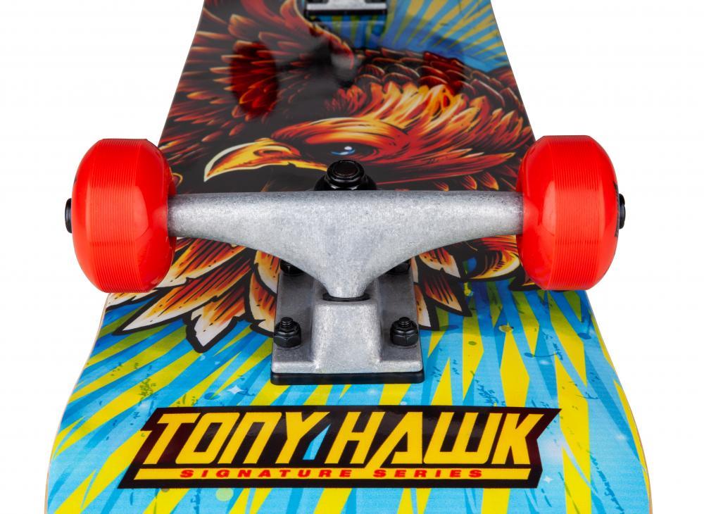Close-up of the Tony Hawk 180 Series Golden Hawk Complete Skateboard (7.75" x 31.5") featuring bright red wheels, metal trucks, and a 7-ply maple deck with an eagle graphic and bold yellow "TONY HAWK" lettering on blue.