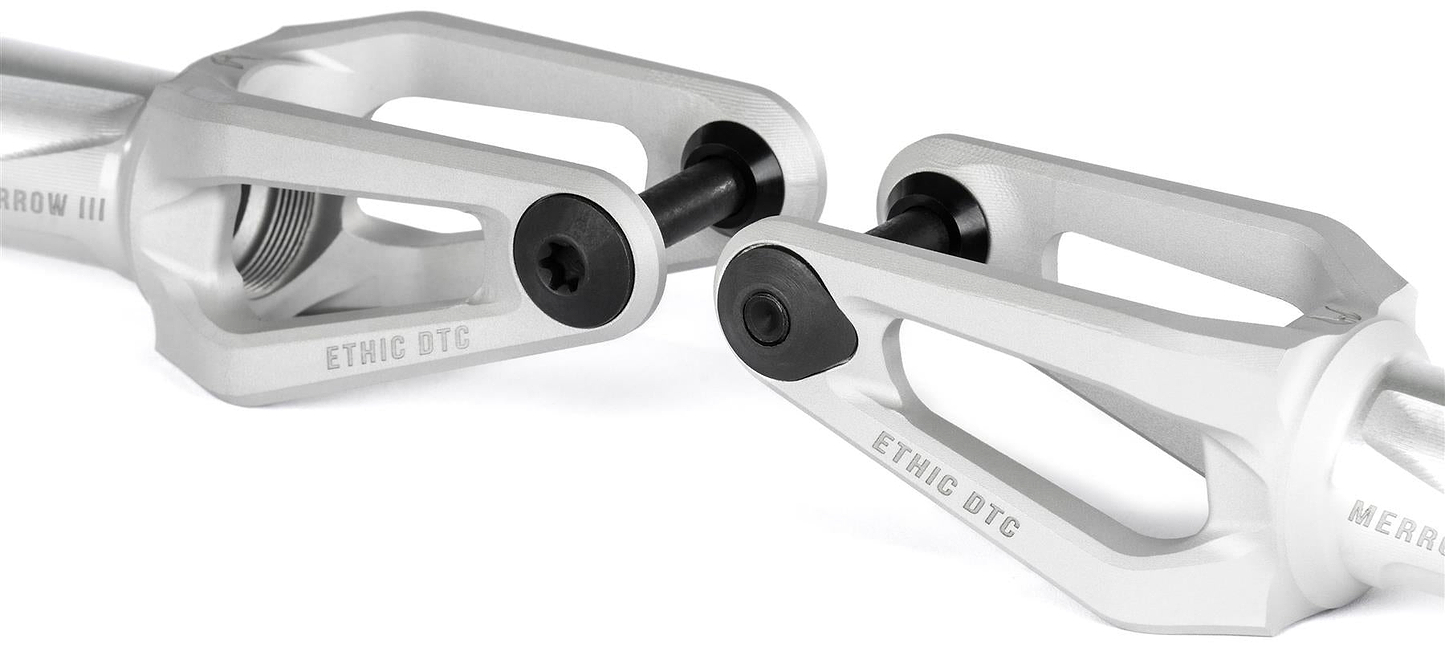 Close-up of two Ethic DTC Merrow V3 8/12STD HIC Stunt Scooter Forks in Raw by Ethic, featuring black bolts and angular design, engraved "ETHIC DTC," displayed against a white background.