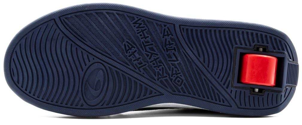 The image shows the sole of Breezy Rollers Hero 2 Shoes - Blue by Breezy Rollers, featuring a dark blue textured surface with grooves, a circular design, and a rectangular slot displaying the patented red wheel system in the heel.