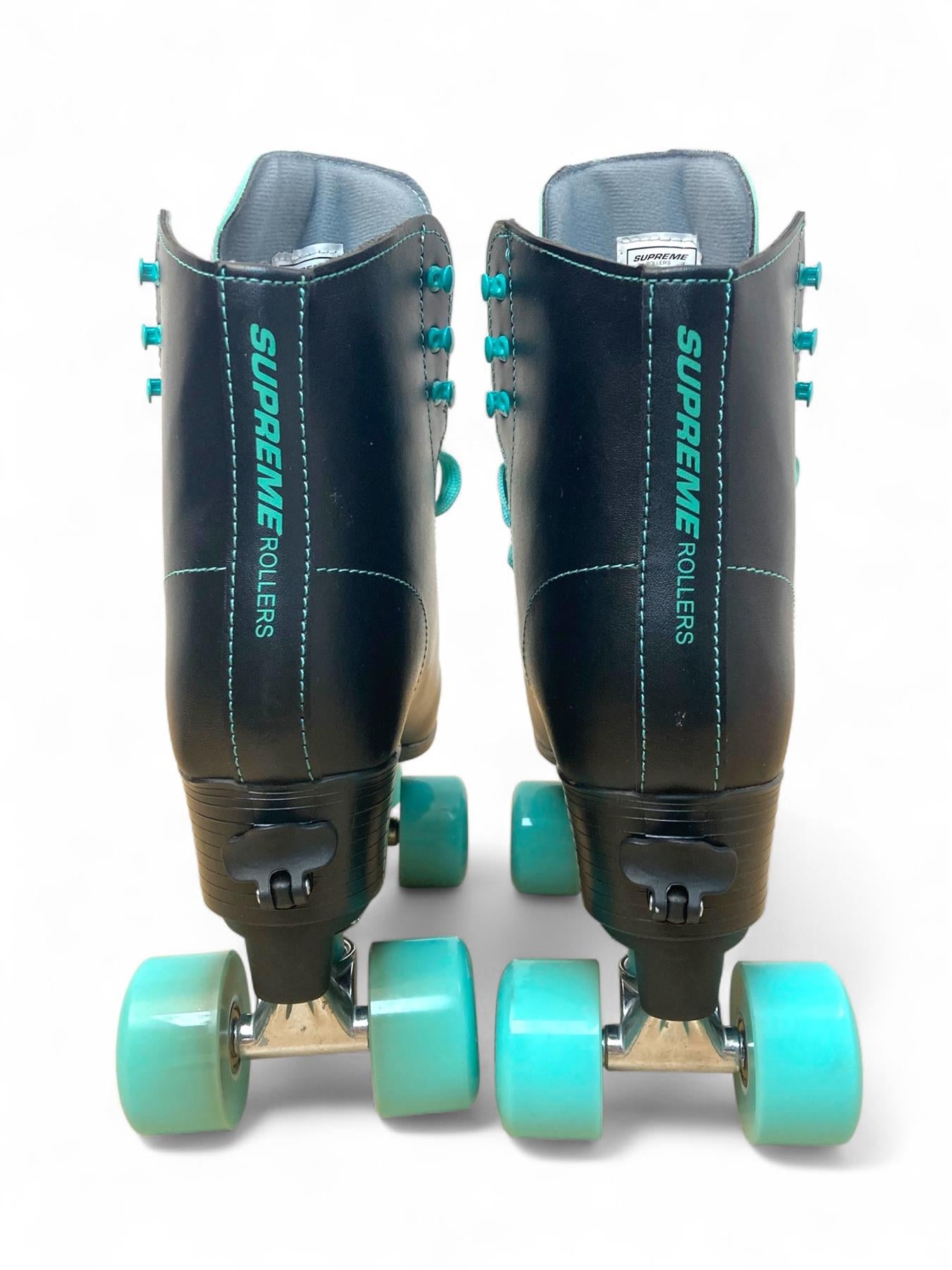 A pair of Supreme Del Rey Adjustable Quad Roller Skates in black, featuring teal wheels and teal laces, is shown from the back on a white background.