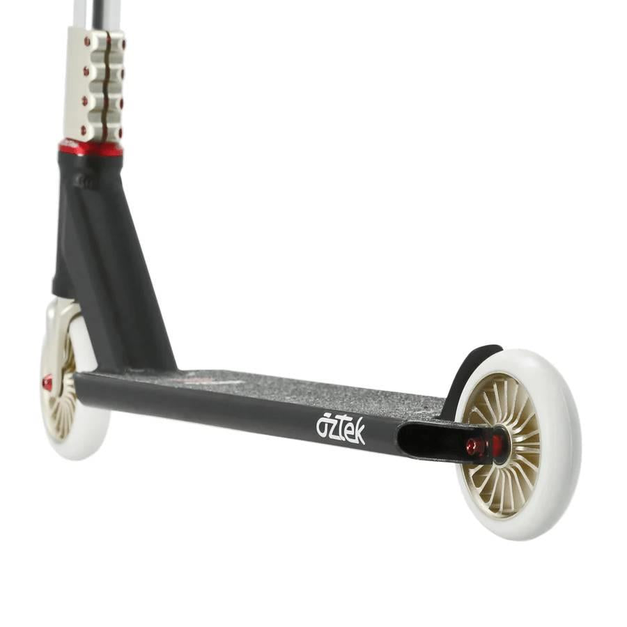 Close-up of the Aztek Corsa Complete Stunt Scooter in black, featuring white wheels, a metal deck, and part of the handlebar stem—ideal for riders who want a lightweight park scooter.