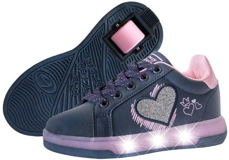 The Breezy Rollers Blast Shoes - Purple by Breezy Rollers feature purple uppers with pink accents, glitter heart designs, and light-up soles. One shoe is upright while the other shows the patented wheel system in these fun wheeled sneakers.