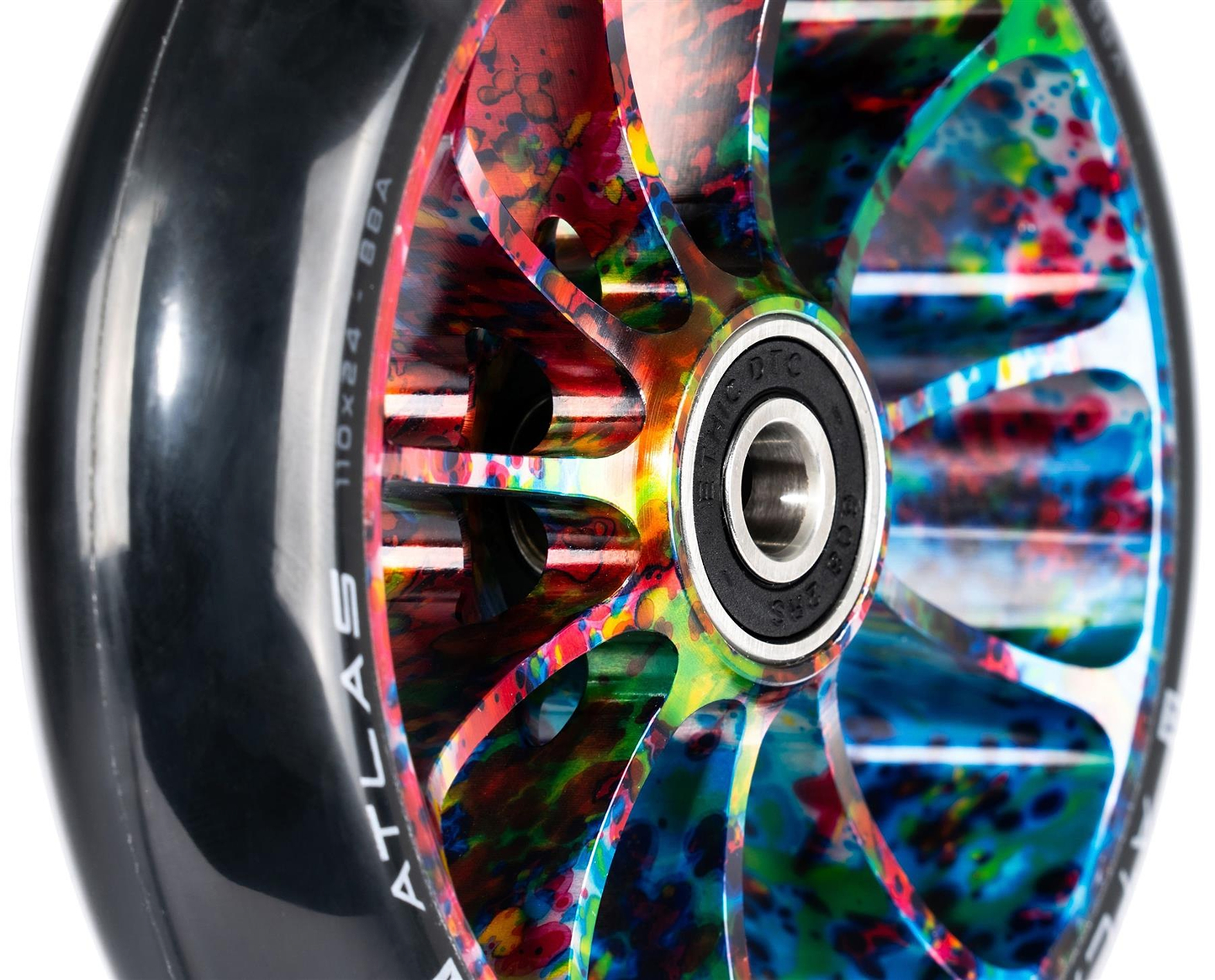 Close-up of the Ethic DTC Atlas 110mm Stunt Scooter Wheel - Nebula, featuring a black tire and a vivid multicolored hub with red, blue, green, and yellow accents. Bearing and metal spokes from Ethic are clearly visible.