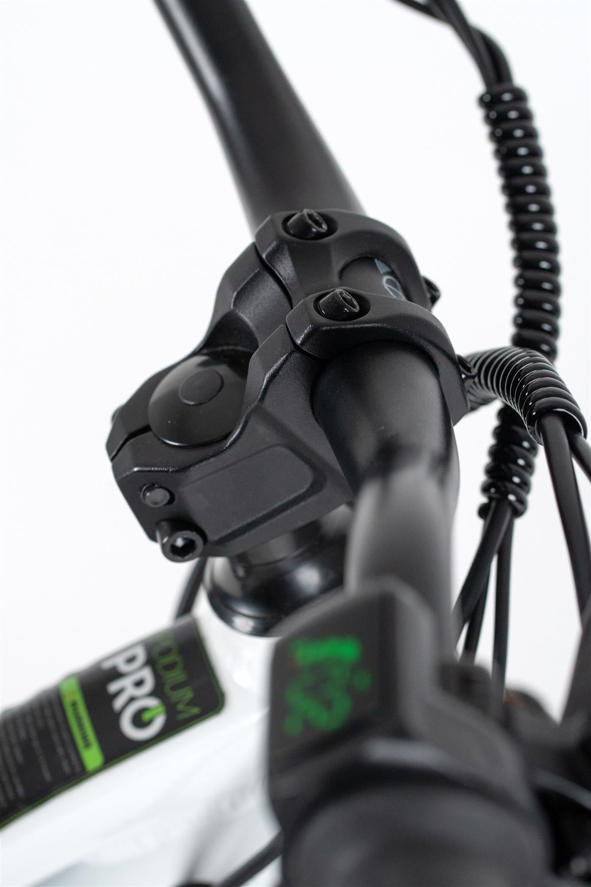 Close-up of Duo 20" Podium Pro Kids Electric Balance Bike handlebar, showing a black control unit, spiral cable, digital display with green numbers, and a "PRO" sticker on the white frame.