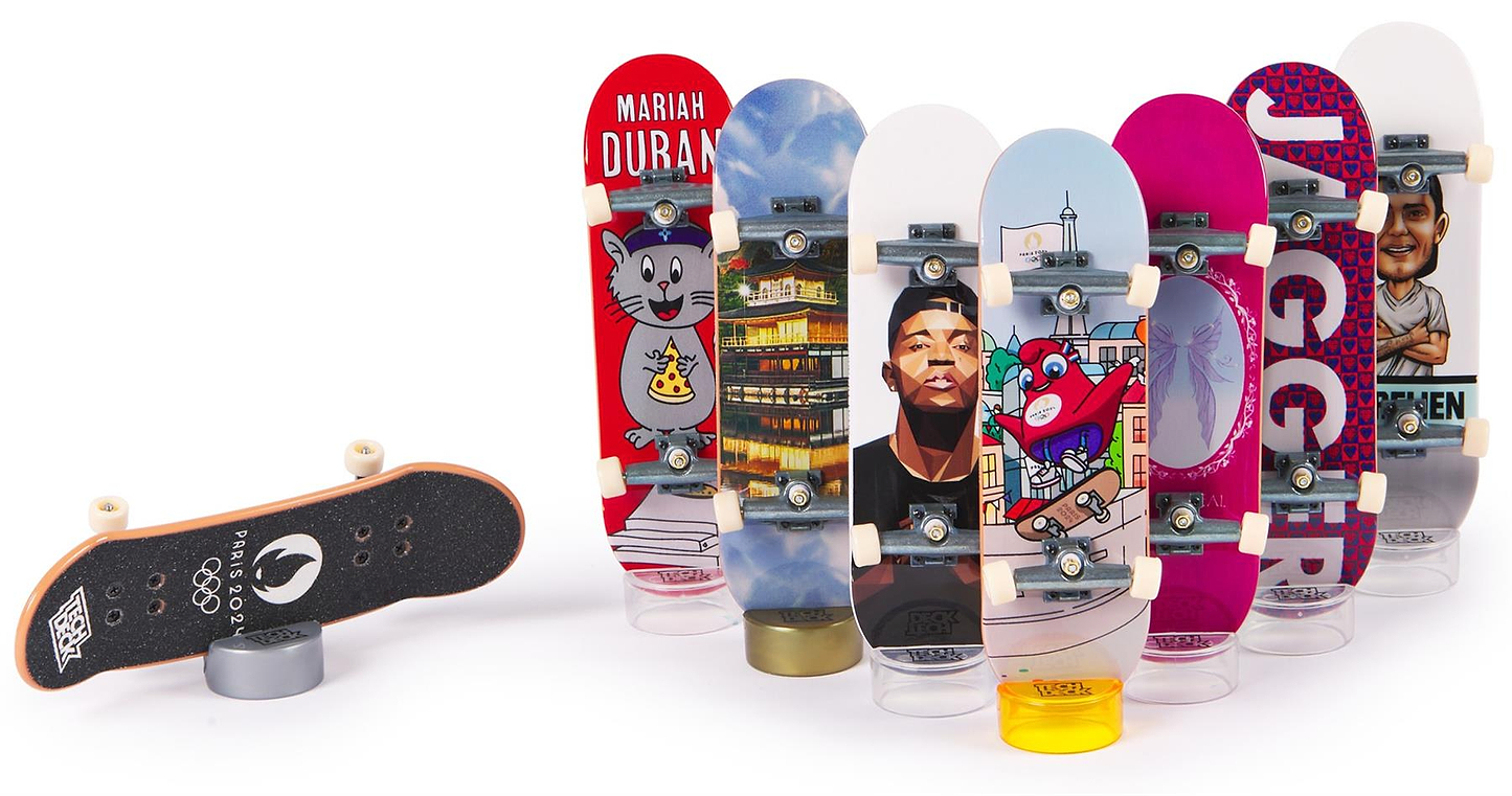 The Tech Deck Olympic Competition Legends Fingerboards 8 Pack features six colorful fingerboards with character and city designs displayed upright, while one lies upside down in front to show its black grip tape.