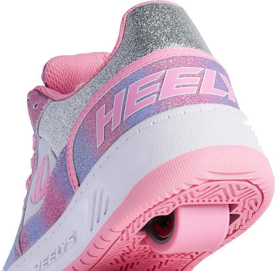 Close-up of Heelys Rezerve Low Girls Shoes in Lt Pink/White/Rainbow, featuring a glittery finish, rear wheel in the sole, pink outsole, and "HEELY" logo—perfect for anyone seeking beginner-friendly Heelys style.