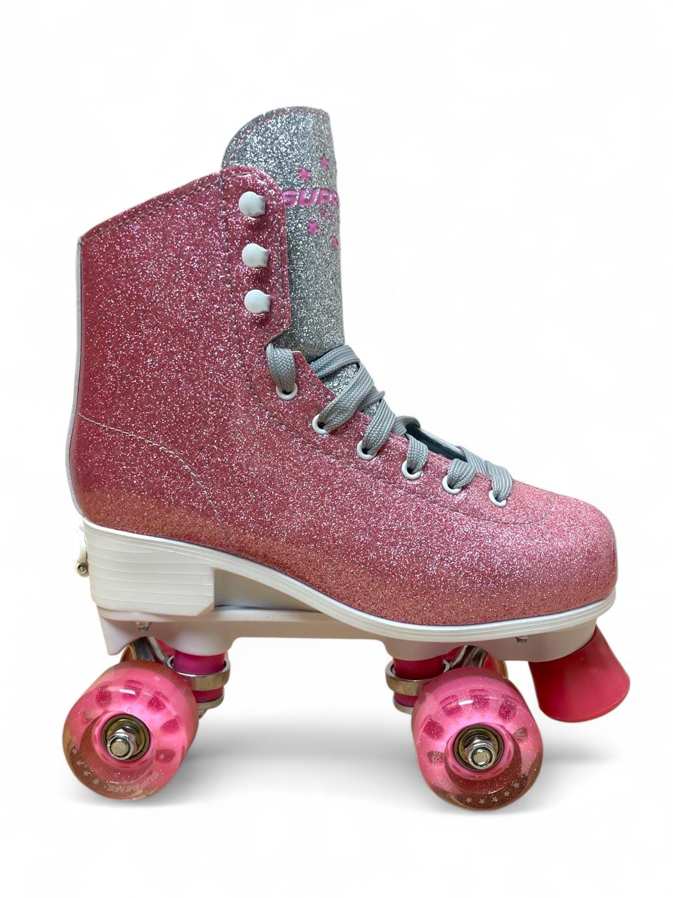 The Supreme Del Rey Adjustable Quad Roller Skates in pink by Supreme feature silver laces, a white sole, and pink wheels—perfect for kids. Shown on a plain white background.