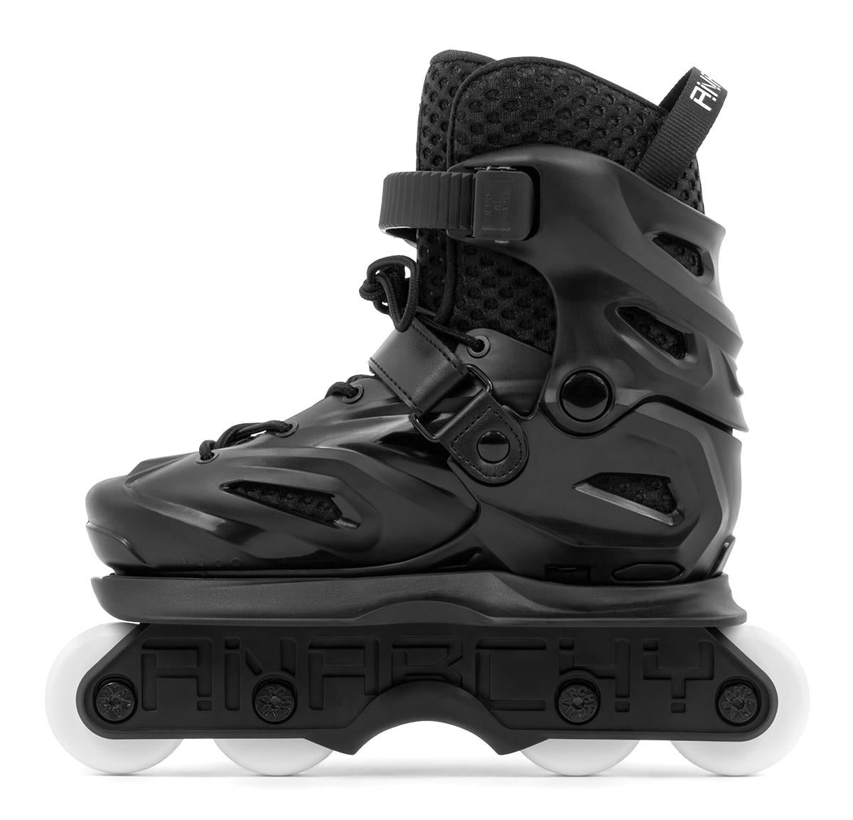 The Anarchy Unity Adjustable Aggressive Inline Skates in black feature a hard shell, ankle strap, laces, and four white high rebound PU wheels. "ANARCHY" is embossed on the black frame above the wheels, as seen from the side.