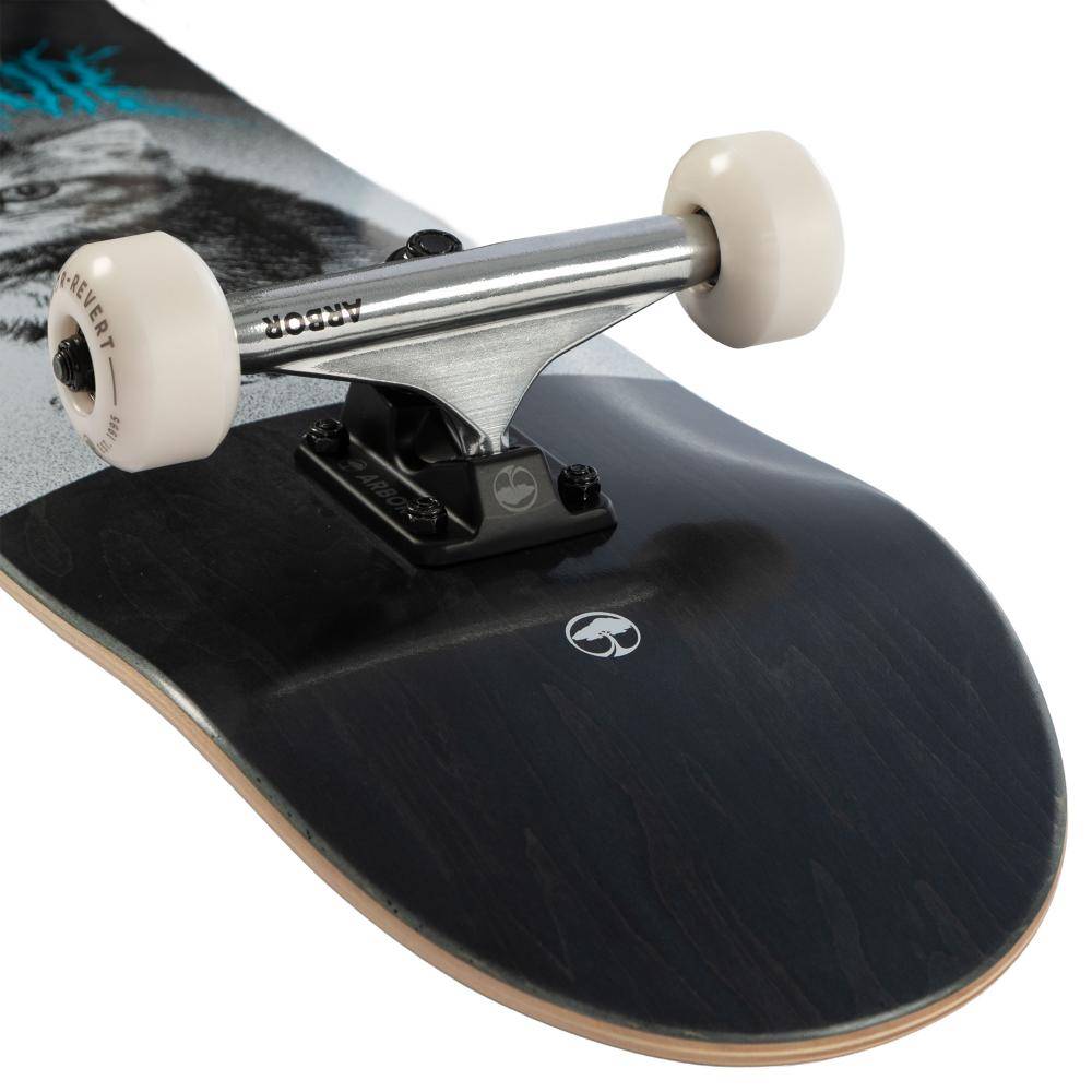 Close-up of the Arbor Street Revert Kitten Complete Skateboard - 8.0″ x 31.75″ rear truck with white wheels on a black Canadian maple deck, showing subtle graphics and exposed wood layers at the edge.