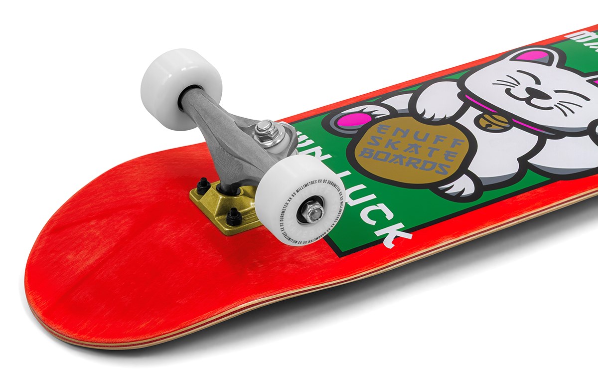 A close-up of the Enuff Lucky Cat Red Complete Skateboard (8.0" x 32") shows a white lucky cat graphic and "ENUFF SKATE BOARDS" text. Silver trucks and white wheels make it ideal for beginners in street or park skating.