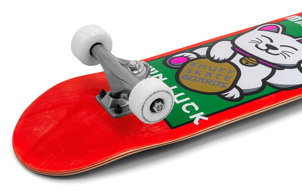 A close-up of the Enuff Lucky Cat Mini Red Complete Skateboard (7.25" x 29.5") by Enuff, a beginner kids’ board with white wheels and a deck featuring a lucky cat holding a gold coin and the words “ENUFF SKATE BOARDS” and “LUCK.”.