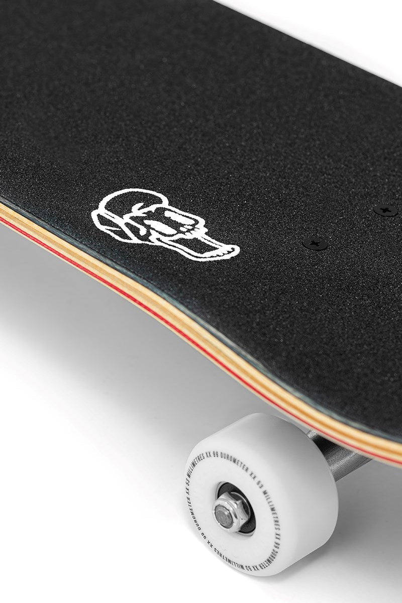 Close-up of the Enuff Three Tier Reloaded Black Complete Skateboard (8.0" x 32.0") by Enuff, featuring black grip tape with a white skull near the edge, exposed wooden layers underneath, and a visible white wheel at the bottom right.