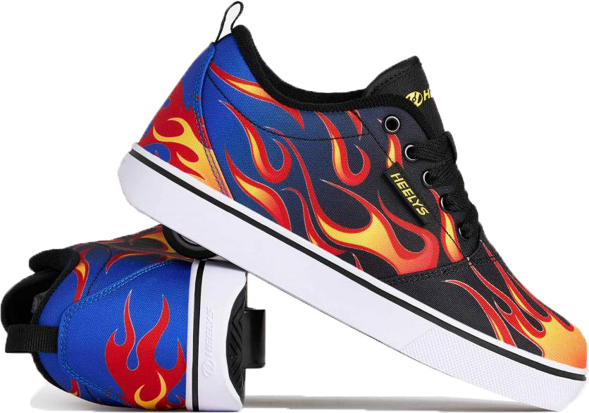 A pair of Heelys Pro 20 Prints Boys Shoes by Heelys, featuring a black and blue base with red and yellow flame designs, black laces, white soles, and a single wheel in each heel. One shoe is upright while the other lies on its side to clearly display the wheel.