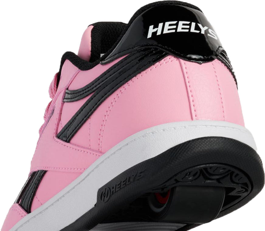 Close-up of the Heelys x Reebok Club C Girls Shoes - Candy Pink / Black / White, featuring a visible wheel in the sole and “HEELY” text—perfect for fans of girls shoes and rolling shoes.