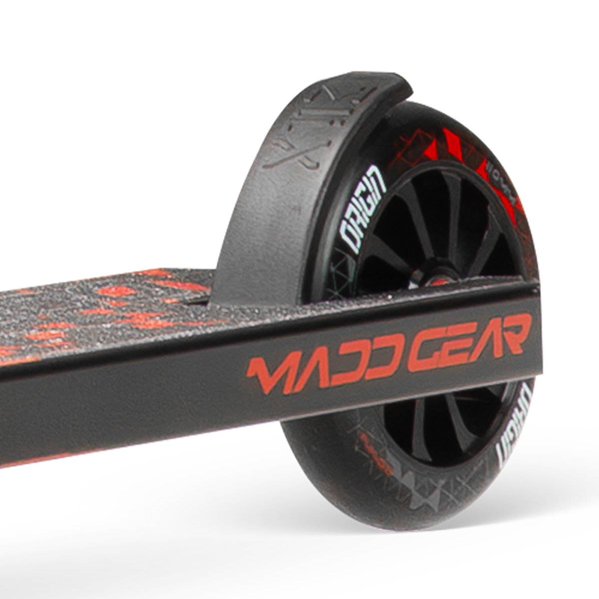 Close-up of the rear wheel and deck (with grip tape) on the Madd Gear (MGP) VX Origin IV 500 Complete Stunt Scooter - Trigon, highlighting the branded stunt scooter wheel and fender.