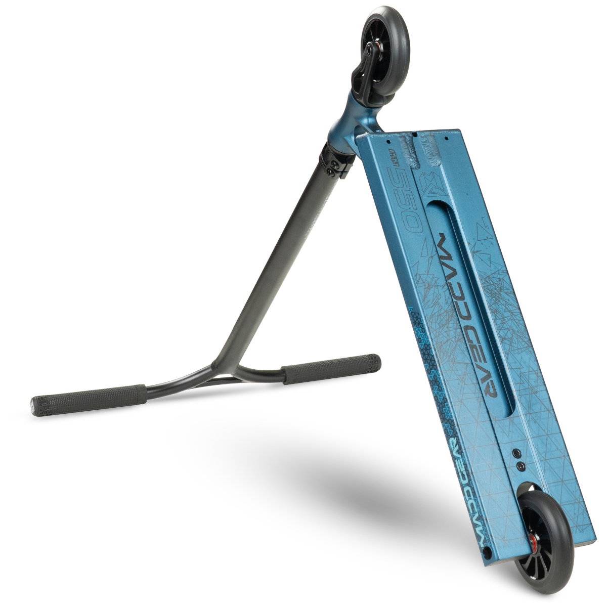 The Madd Gear (MGP) VX Origin IV 550 Complete Stunt Scooter in Denim is a blue park scooter with black handlebars and wheels. Shown at an angle, its deck displays the MGP VX Origin IV 550 logo and geometric patterns.