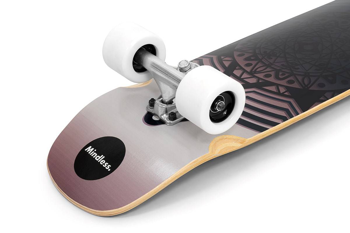 Close-up of the Mindless Drifter Cruiser Skateboard 28″ x 8″ - Black tail, featuring white wheels, silver trucks, and geometric deck patterns. The word “Mindless” appears near the tail.