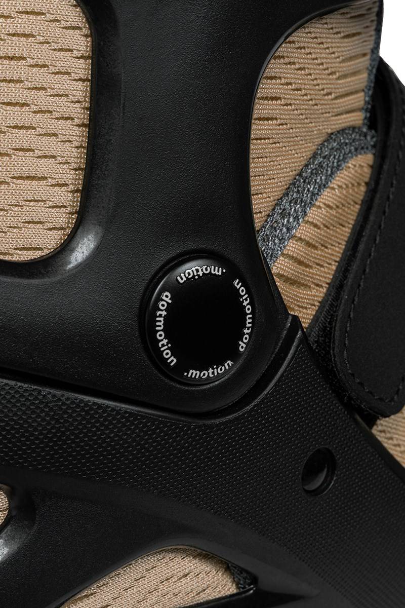 Close-up of a tan .motion Dreamstate Fly Inline Skates - Sand boot featuring a black structural support with a circular logo containing the word “dotmotion.”