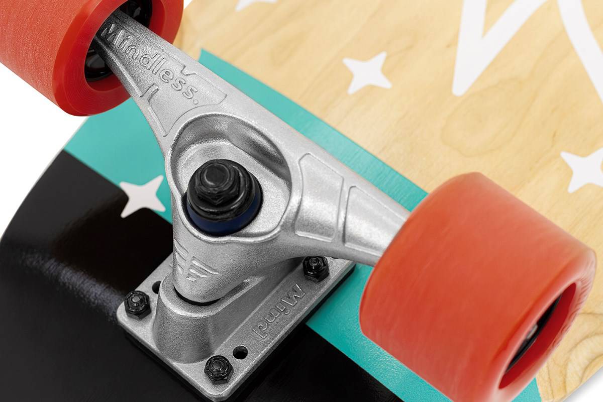 Close-up of a Mindless Soul Surf Skate Cruiser Skateboard 29.5″ x 9.75″ - Red truck with red wheels on a wooden deck featuring black, teal, and white star designs, with “endless.” engraved on the truck.