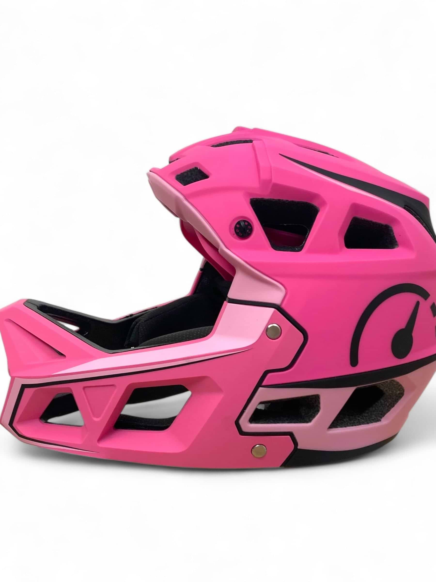 The Revvi Kids Full Face MTB Helmet in bright pink features black interior padding, angular vents, and bold black graphics—ideal for young riders. Displayed on a plain white background. Brand: Revvi.