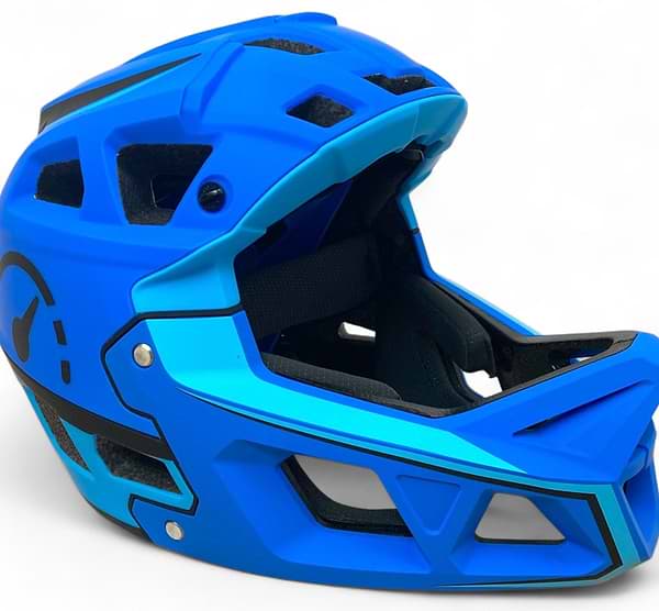 The Revvi Kids Full Face MTB Helmet - Blue by Revvi features a bright blue design with black accents, a large chin guard, multiple ventilation openings, and geometric patterns. This lightweight kids helmet is shown on a plain white background.