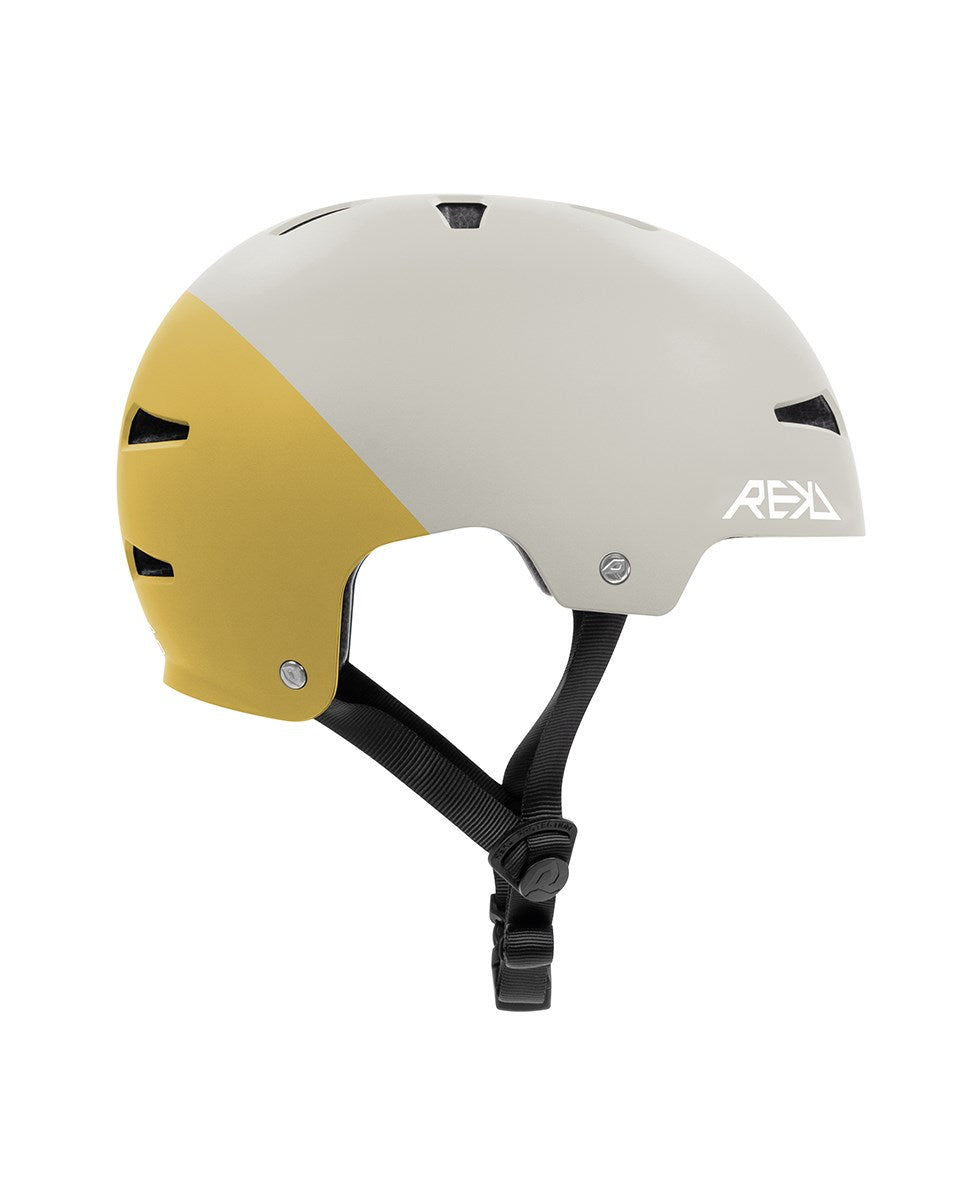 The REKD Elite 2.0 Skate / Scooter Helmet in grey/yellow features a matte two-tone finish, ventilation slots, black adjustable straps, and a white REKD logo on the side. Lightweight design ideal for action sports.